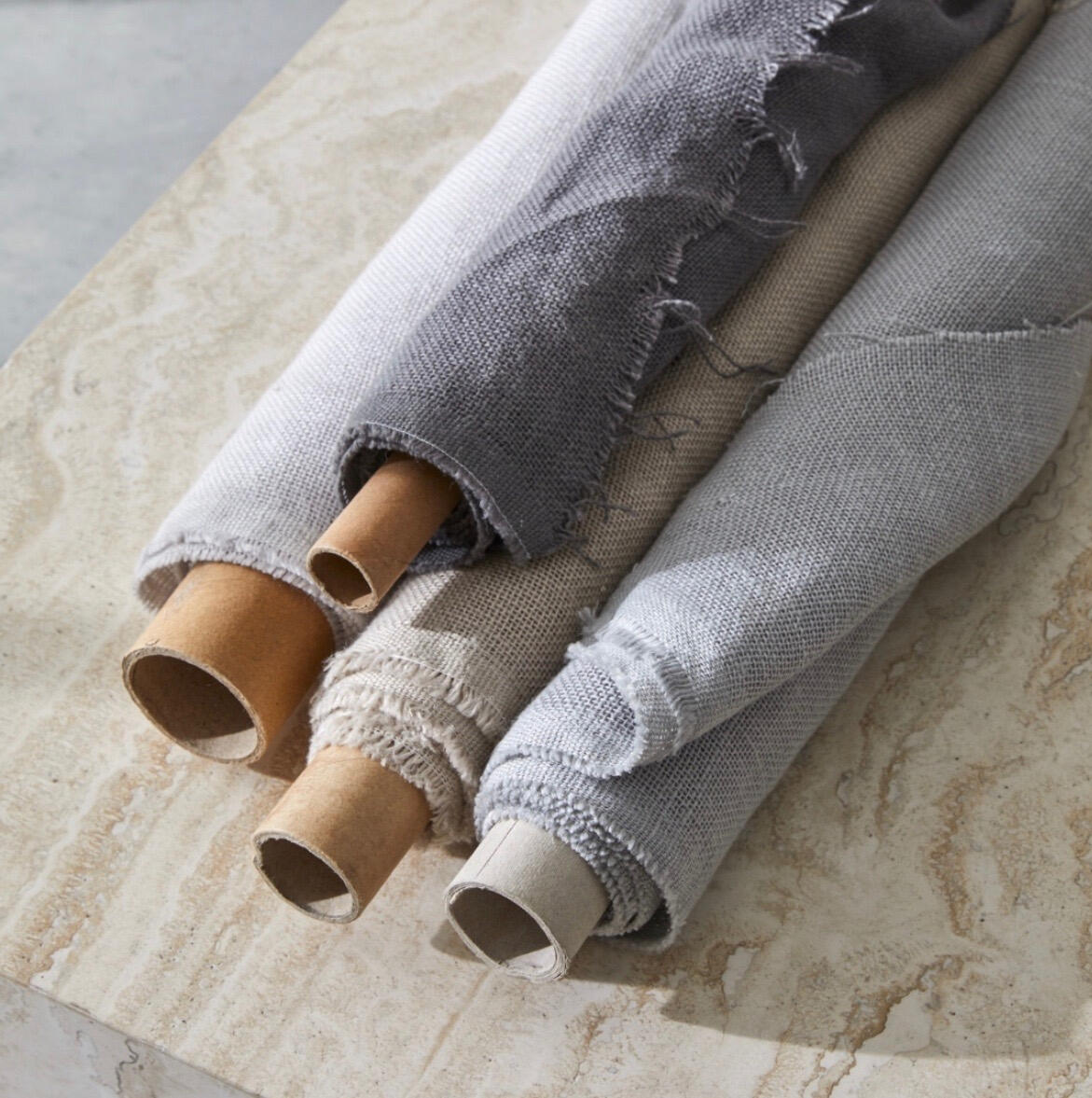 Rolls of linen fabric in shades of grey